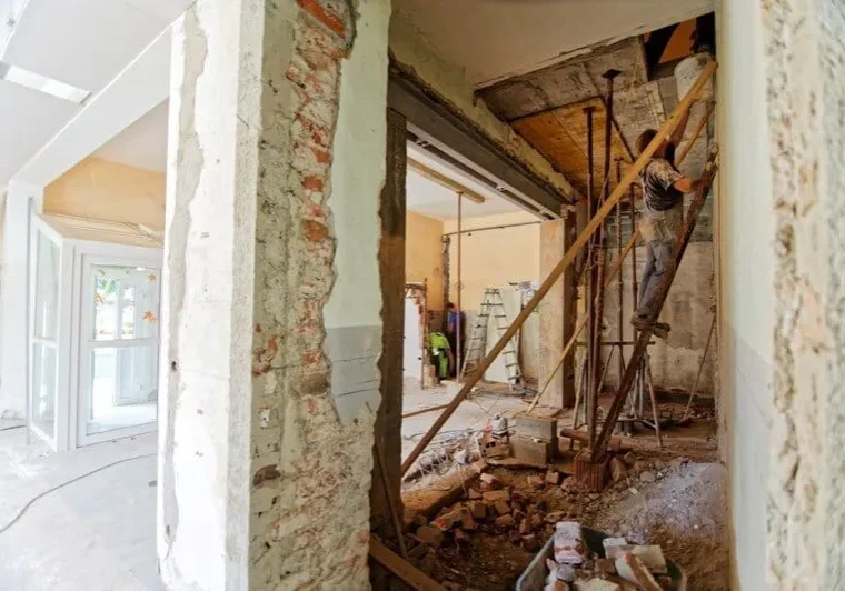 House undergoing extension with scaffolding and construction work in progress.