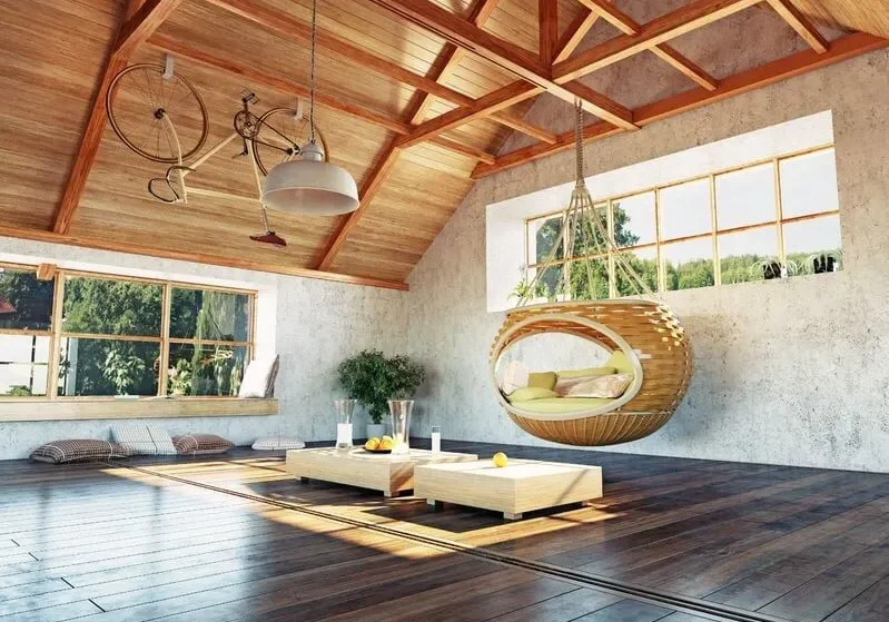 Chic modern attic living space with a cozy hanging sofa and minimalist decor.